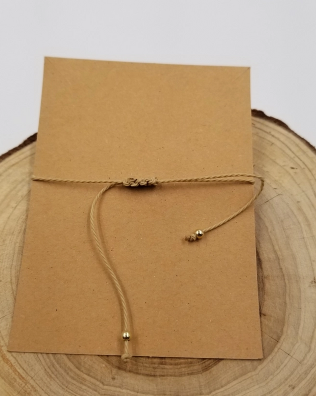Chakra Jewelry zodiac constellation bracelet with adjustable beige cord on brown card