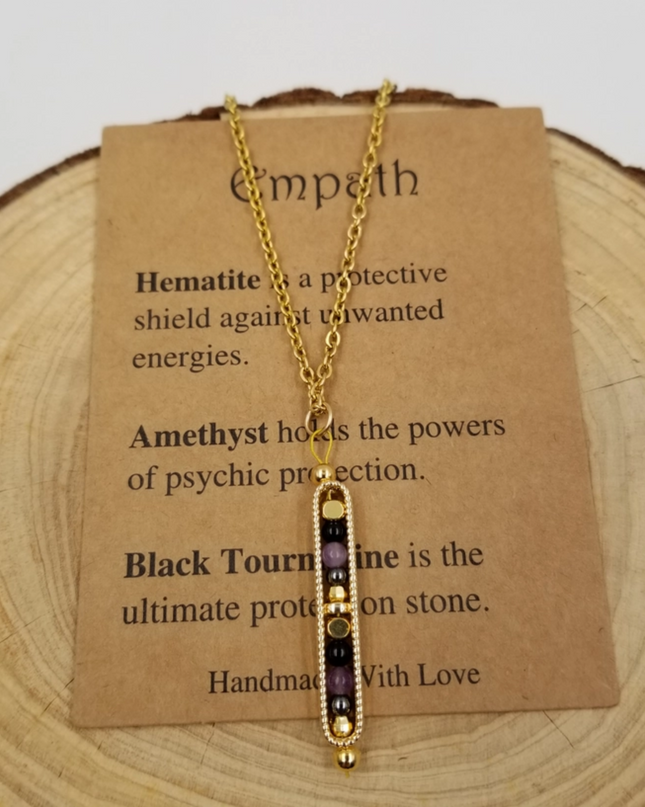 Chakra Jewelry necklace with inspirational card featuring protective gemstone meanings on a wooden background