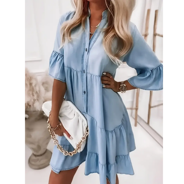 Light blue denim ruffle dress with button-down front and tiered sleeves styled with white clutch